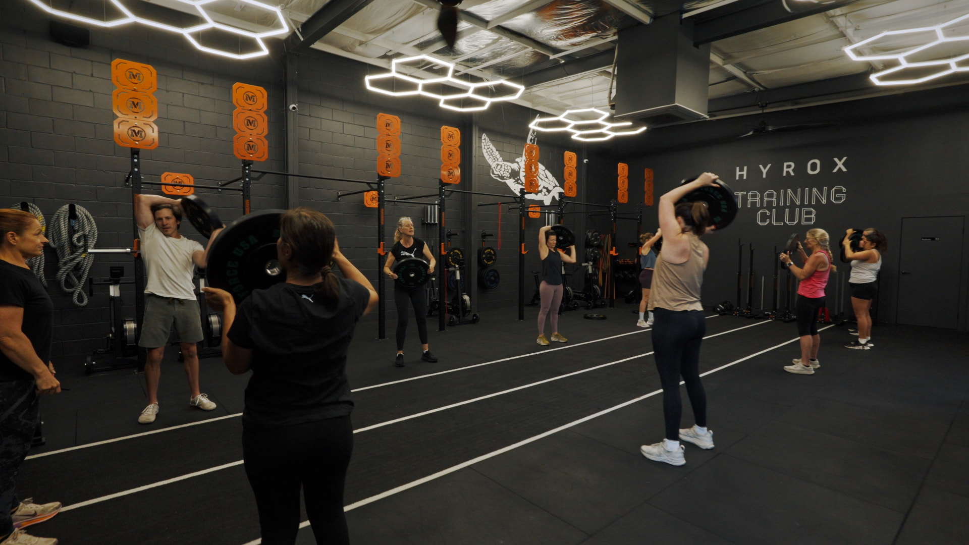 Class pressing weight plates overhead